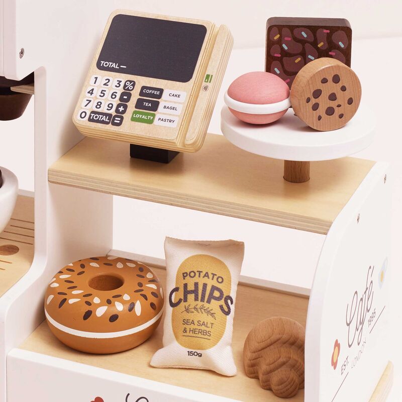 Toy cash register with miniature food items on a white background