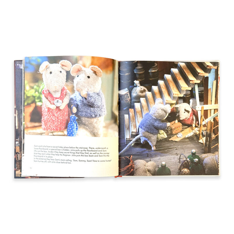 Open book showing illustrations of toy mice on a wooden staircase.