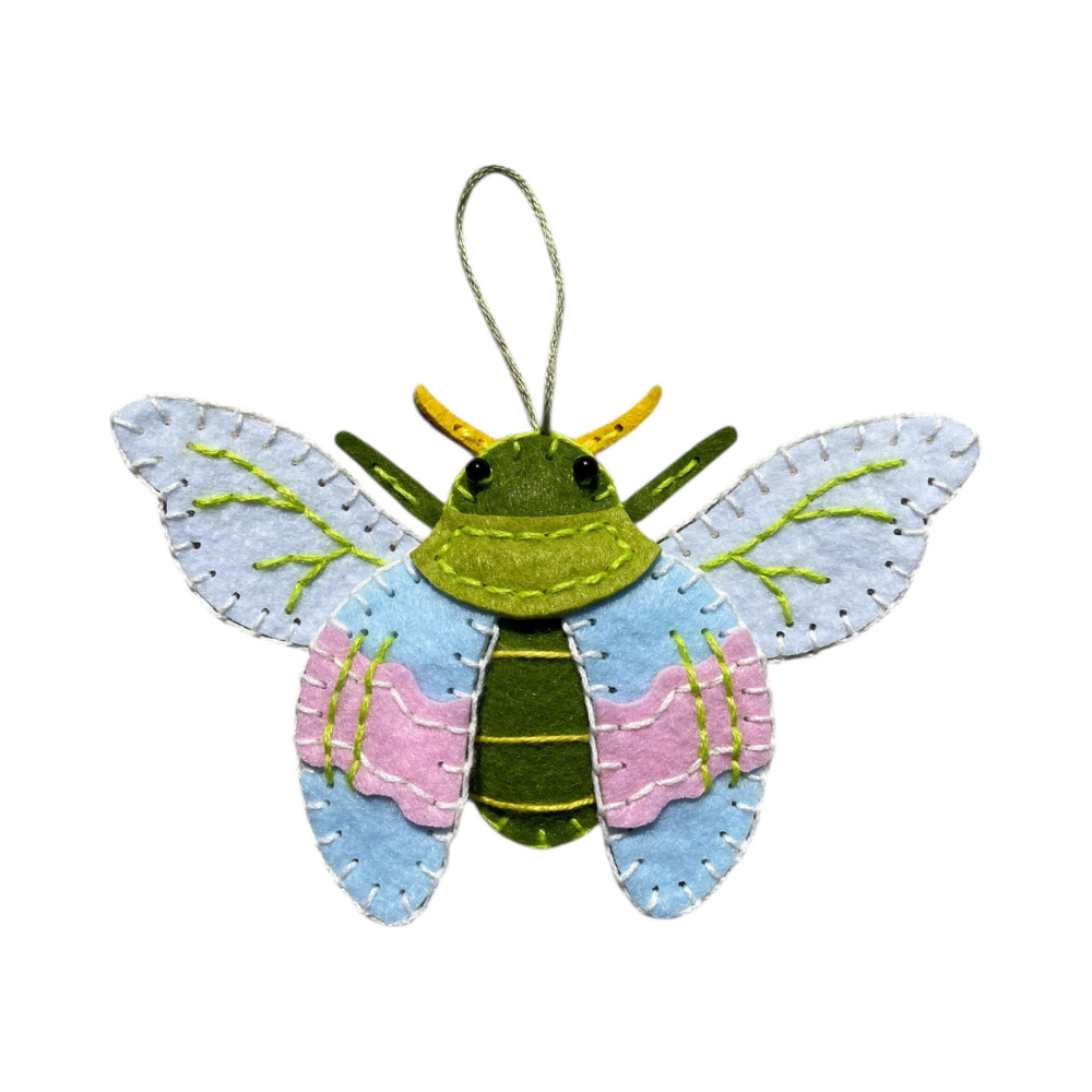 Colourful felt bug ornament on a white background