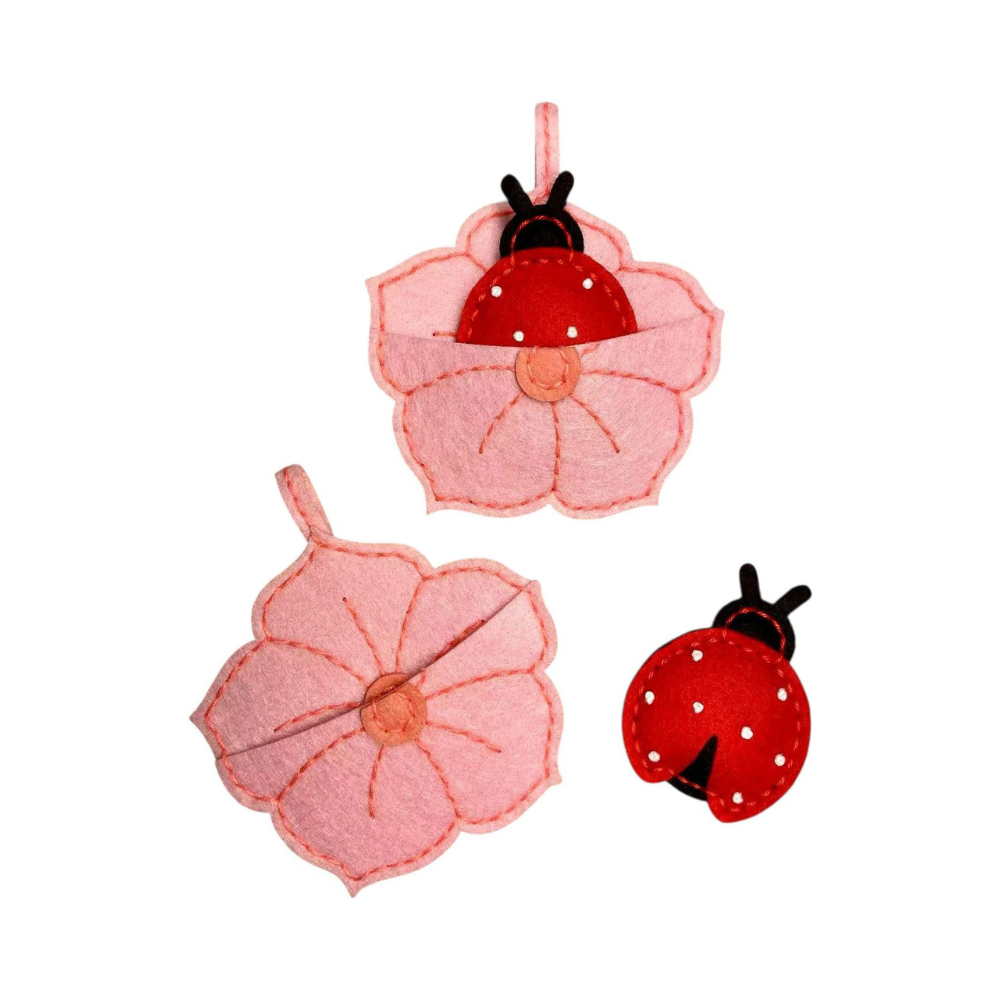 Felt ladybug and flower decoration on a white background