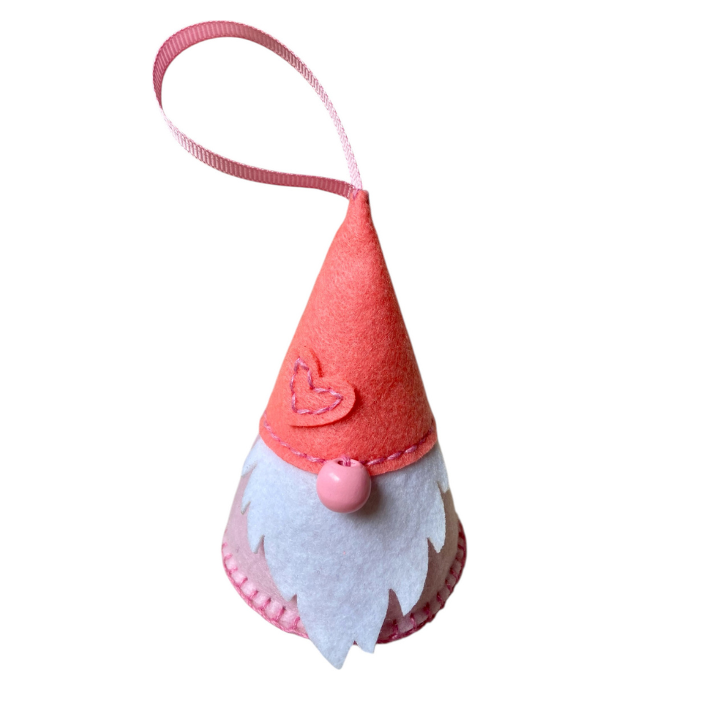 Felt gnome ornament with a pink hat and white beard on a white background